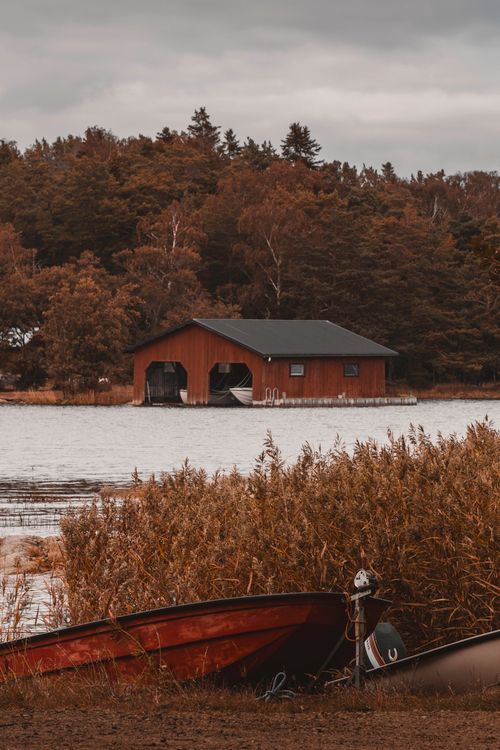 Free Rustic boat shed on the Åland Islands shore captures a serene Finnish landscape. Stock Photo