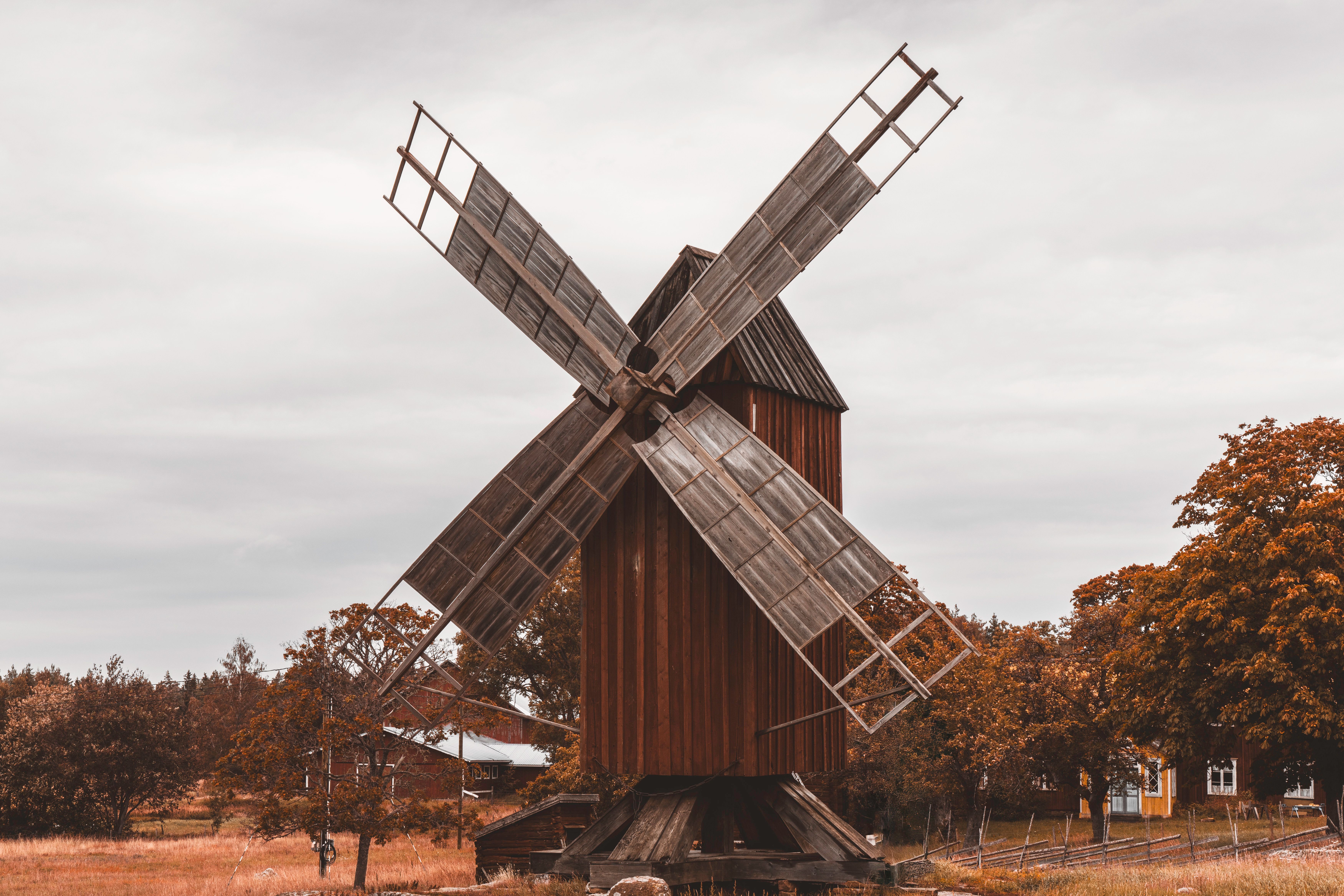 Charming view of a vintage wooden windmill surrounded by autumn foliage in Åland Islands countryside.. Photo by Raul Ling on Pexels
