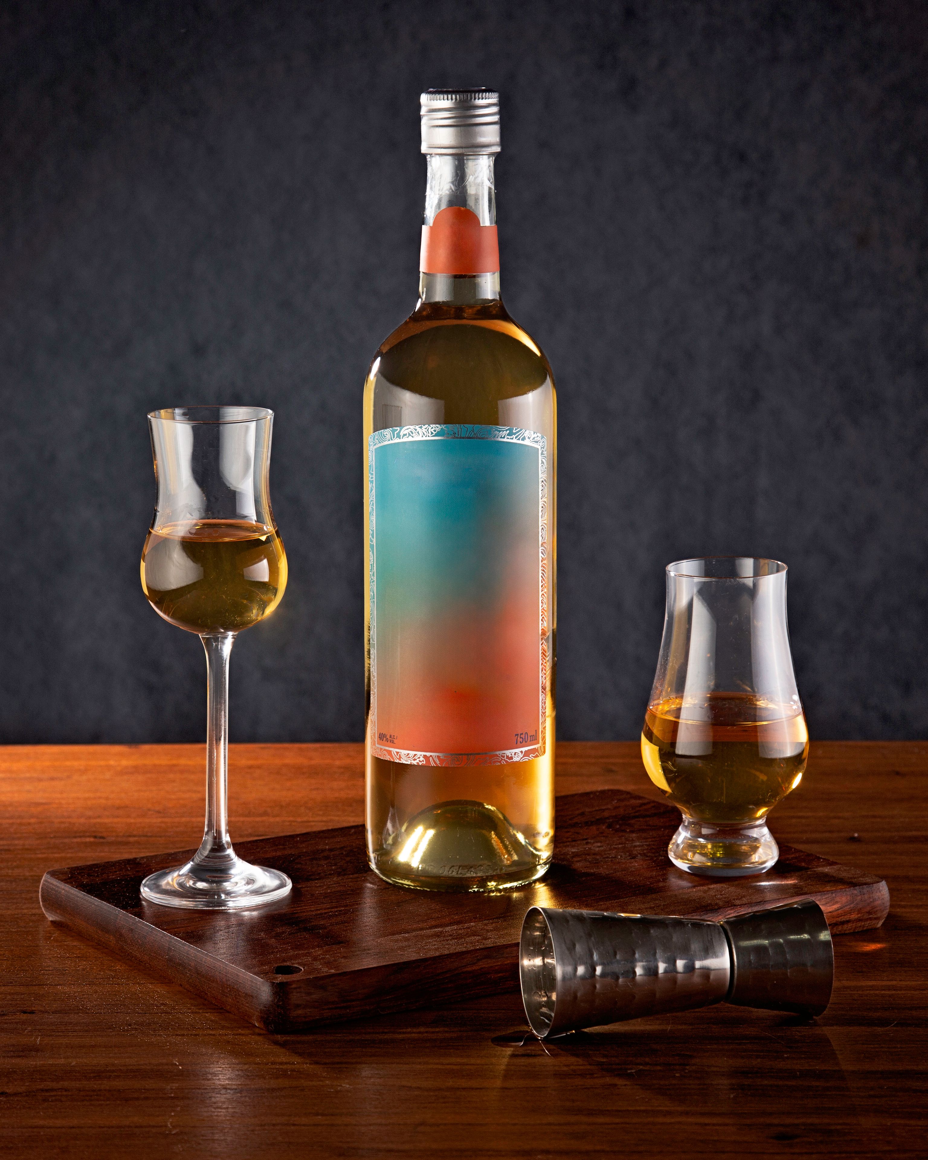 An elegant whiskey bottle with two glasses on a wooden tray, perfect for drink enthusiasts.