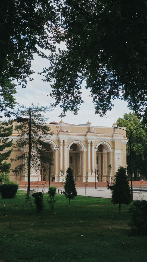 Free A beautiful neo-classical building surrounded by lush greenery in an urban park. Stock Photo