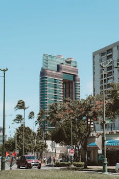 Photo by Andres Daza Modern skyscrapers and palm trees under clear skies in Honolulu, Hawaii.