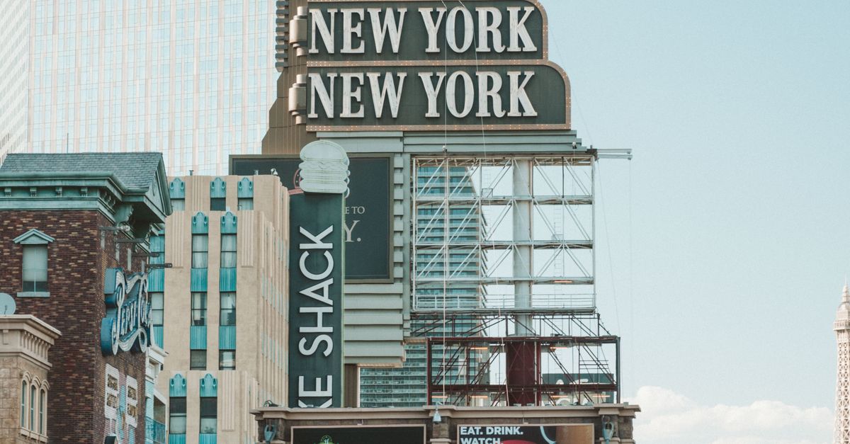 Daytime view of the New York-New York Hotel sign with surrounding architecture in Las Vegas.