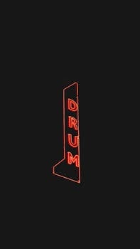 Minimalistic neon drum sign glowing in the night in Kansas City.