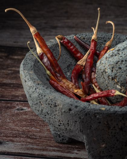Dried red chilli peppers in a stone mortar. Photo by Alejandro Aznar on Pexels.
