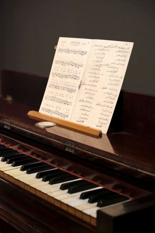Free A wooden piano with musical sheets displayed, showcasing its keys and elegant design. Stock Photo