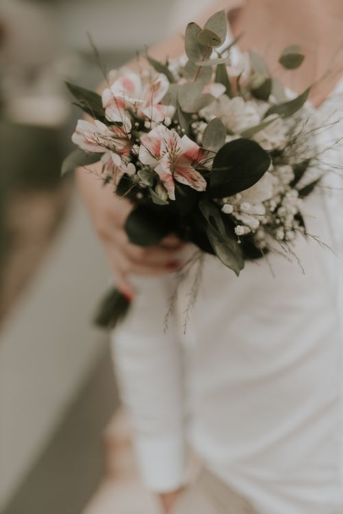 Free A close-up of an elegant bridal bouquet featuring pastel flowers and greenery. Stock Photo