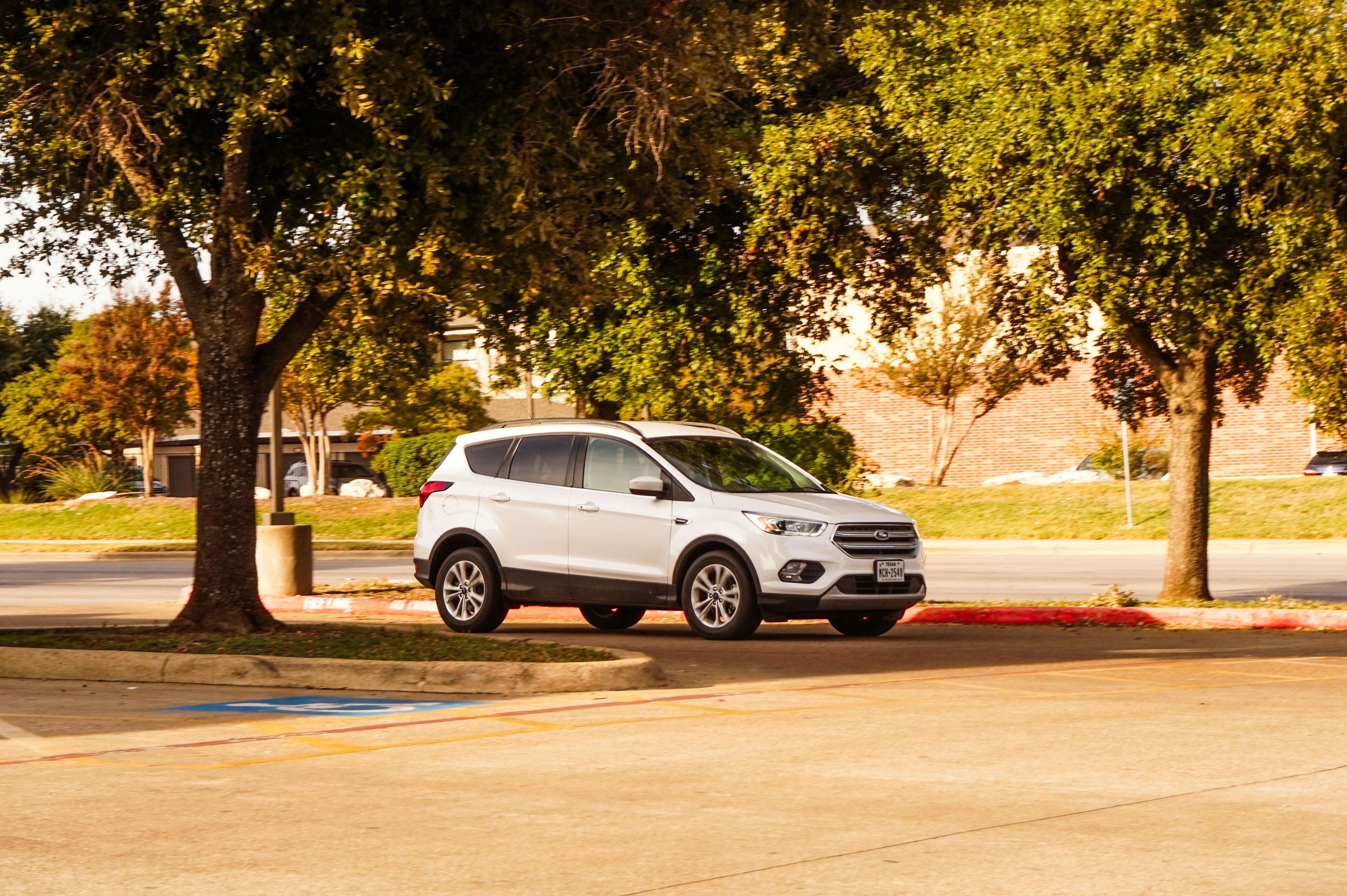 Modern family SUV parked in a suburban driveway - kia seltos s price