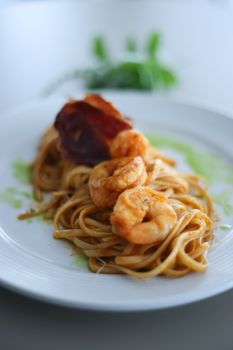 Delicious shrimp pasta garnished with herbs on a white plate, perfect for gourmet dining.