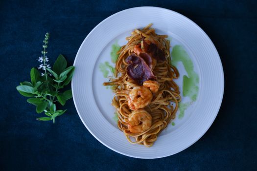 Delicious shrimp pasta with fresh herbs on a white plate, perfect for seafood lovers.