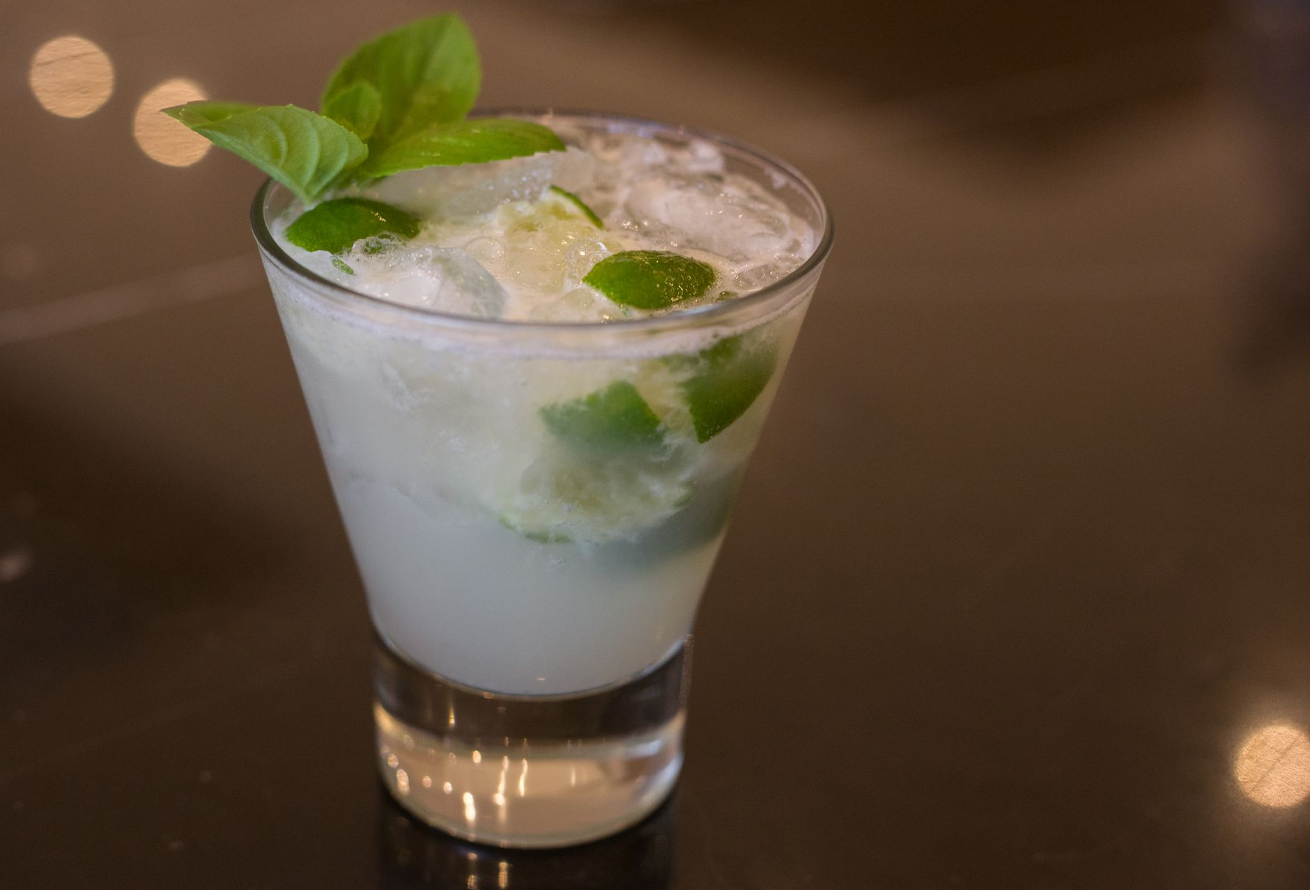 Fresh basil leaves and lime on wooden cutting board
