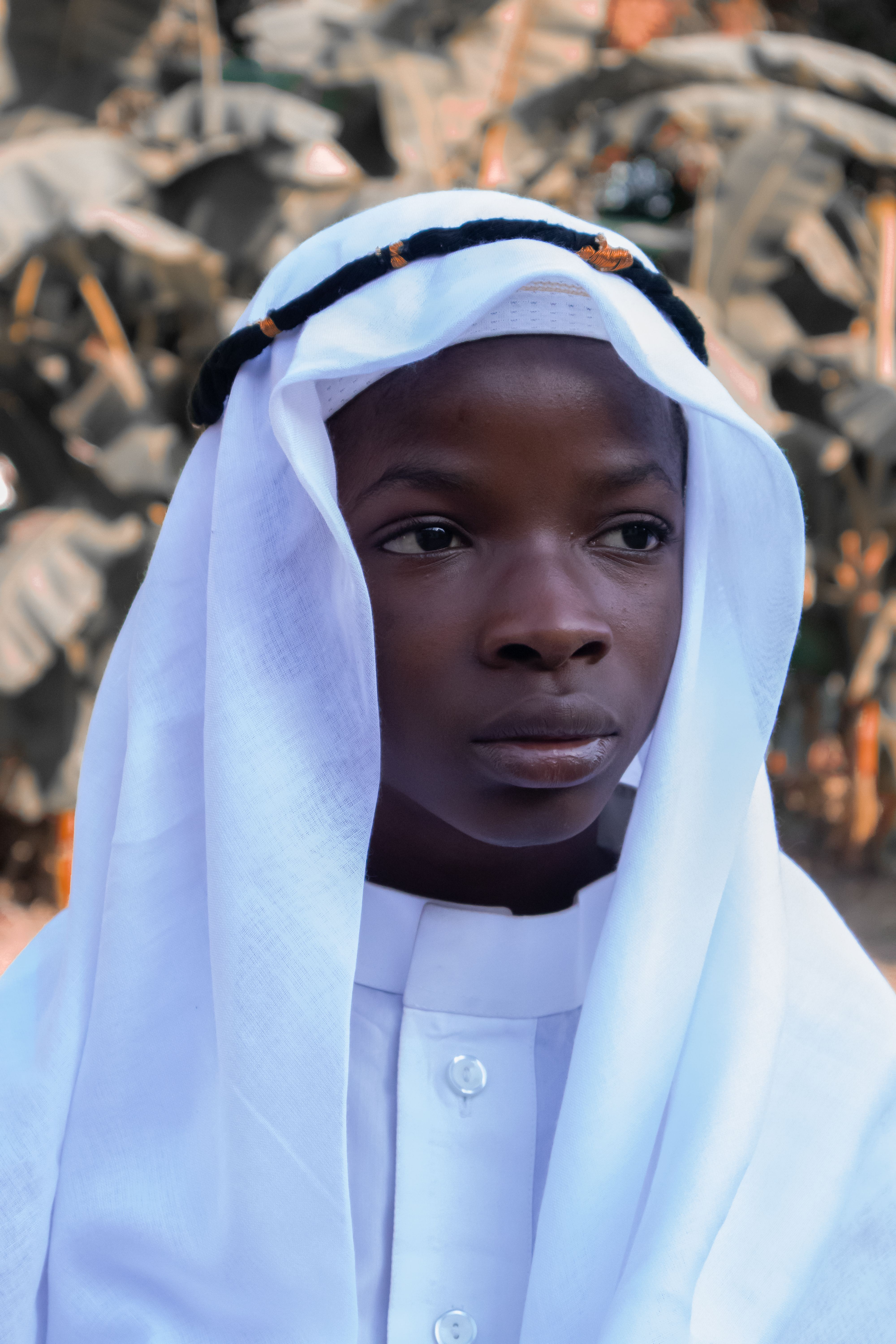 A solemn portrait of an individual wearing traditional attire, capturing cultural essence.