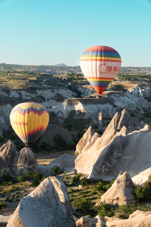 Free Vibrant hot air balloons floating over Cappadocia's unique rock formations at sunrise. Stock Photo