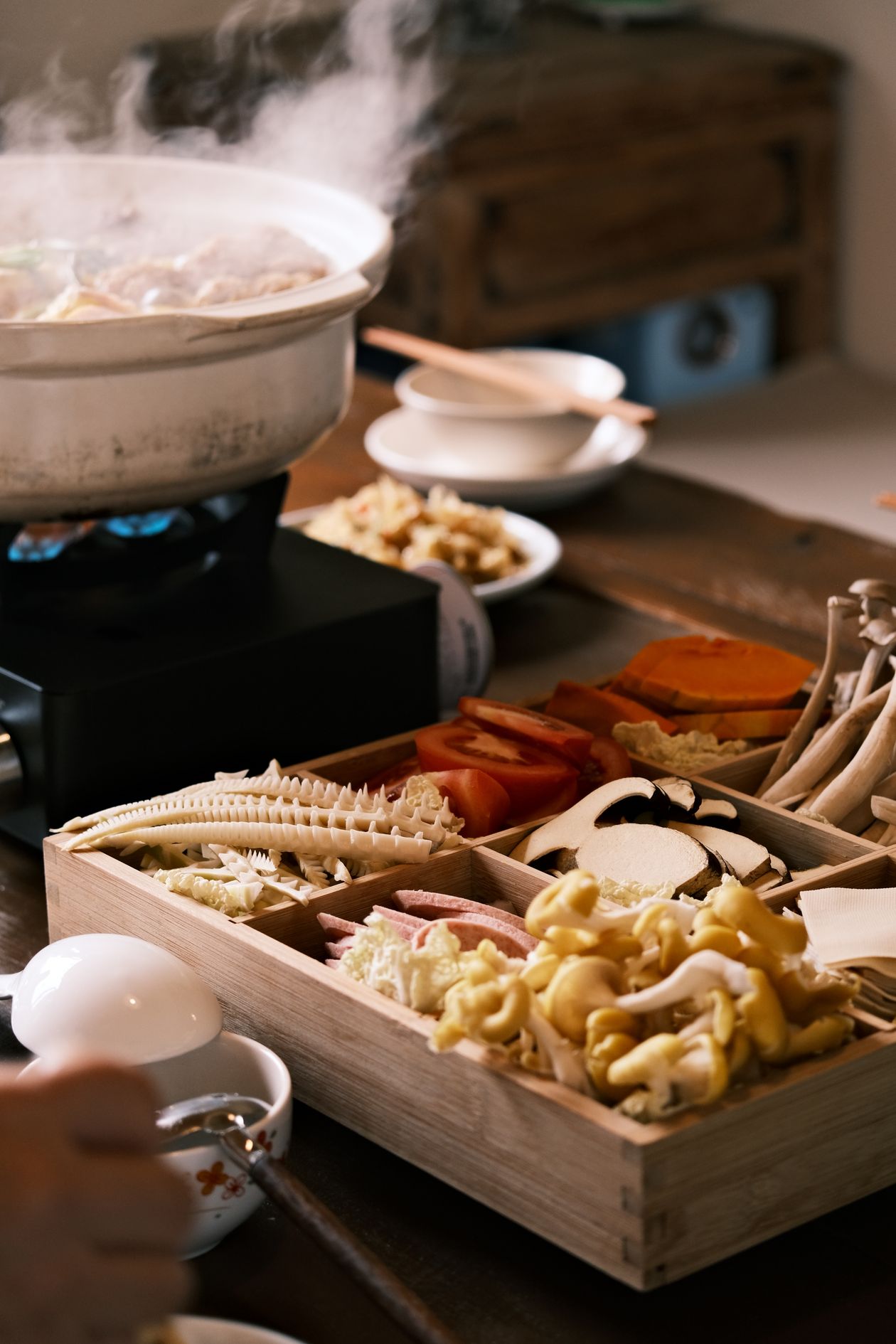 Nồi lẩu đang sôi với đầy đủ thịt, rau và nấm tươi