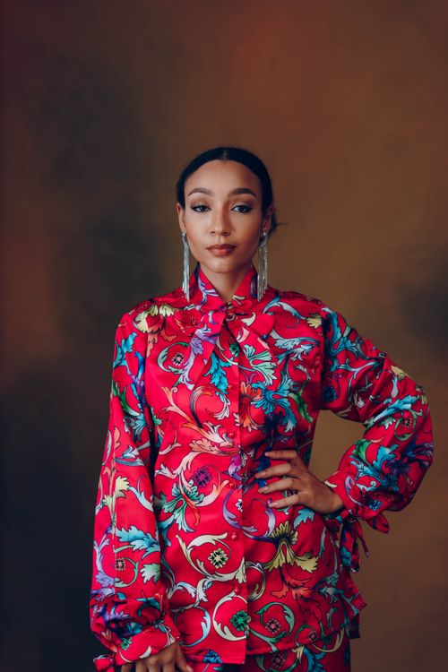 Free A stylish woman in vibrant clothing poses gracefully against a neutral background. Stock Photo