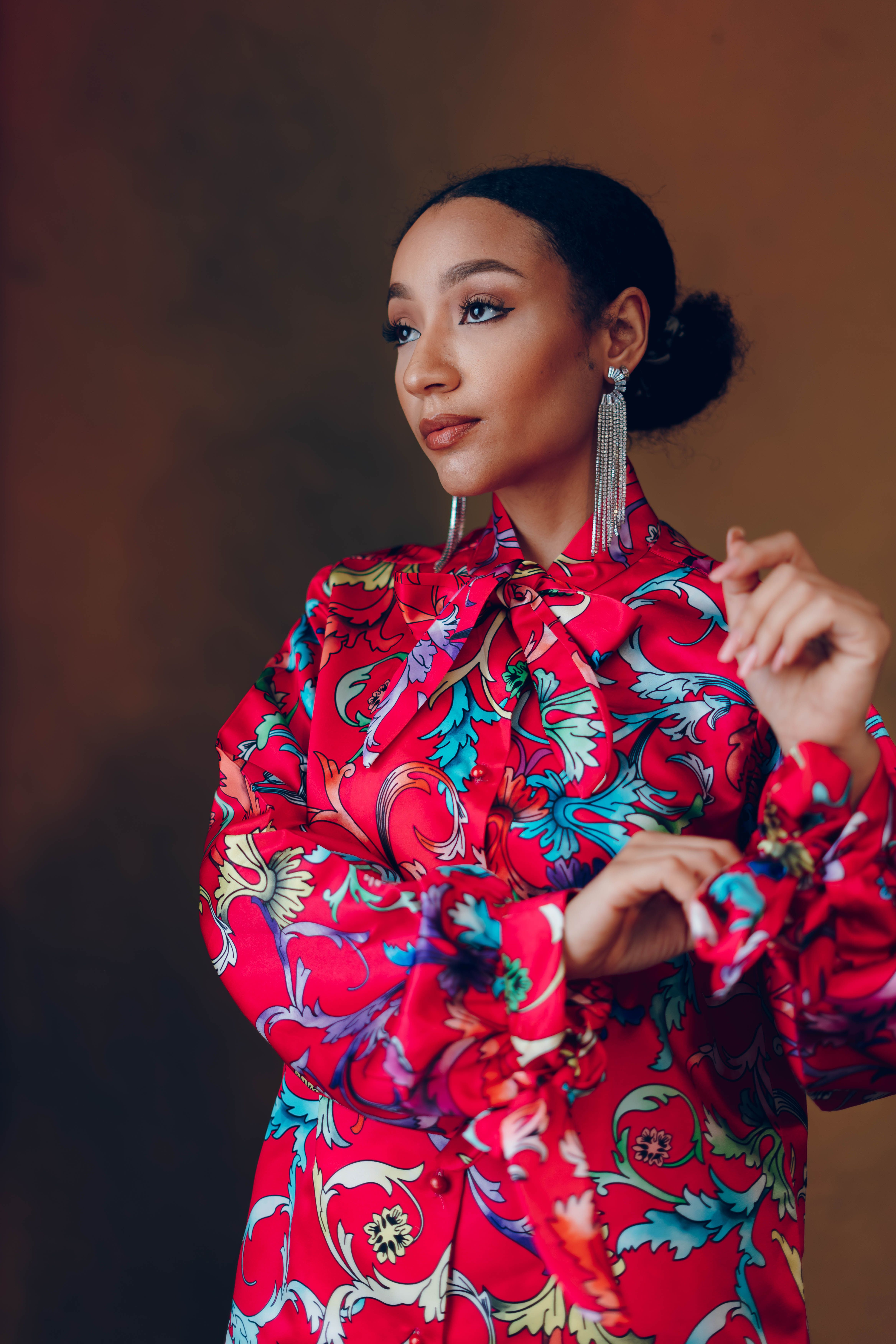 Elegant Woman Posing in Vibrant Floral Dress · Free Stock Photo