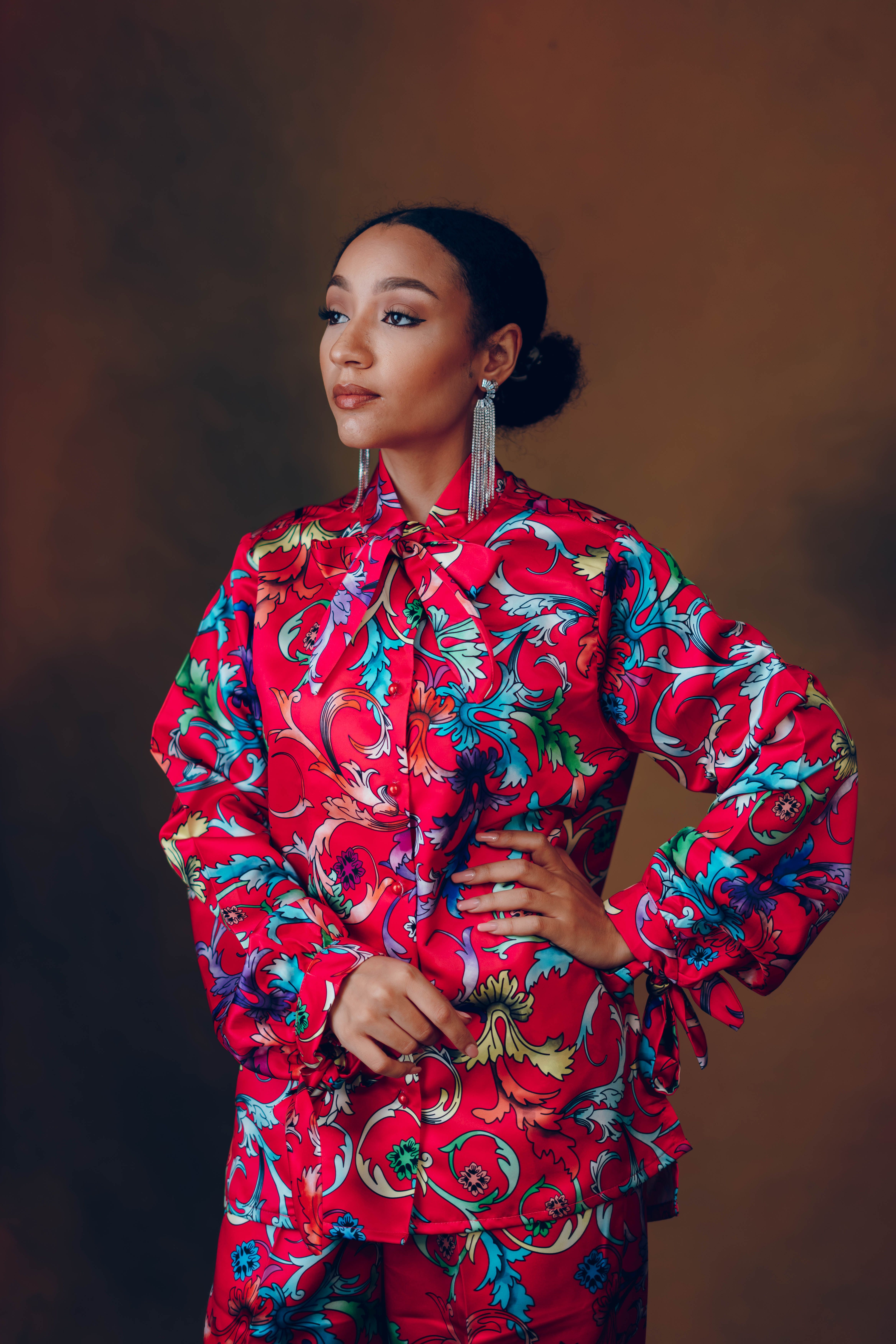 Elegant portrait of a woman in a vibrant floral dress exuding confidence and style.