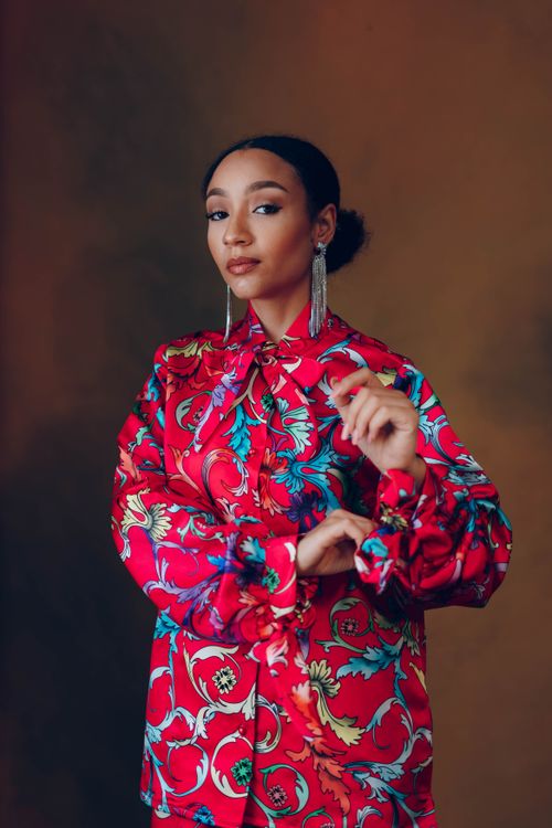 Free Elegant portrait of a woman in a vibrant patterned blouse, showcasing modern fashion. Stock Photo