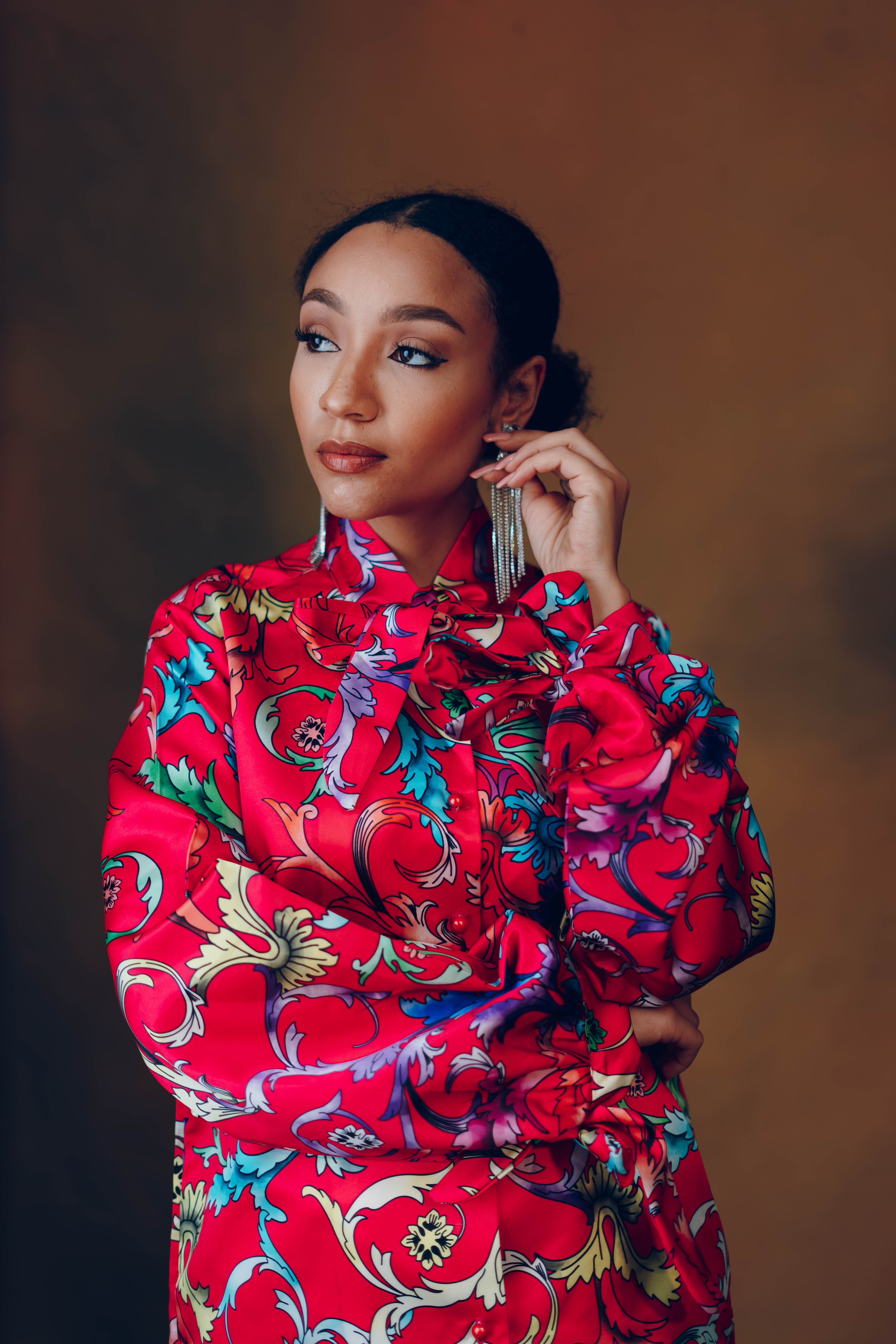 An elegant portrait of a woman in vibrant patterned fashion, exuding confidence and style.