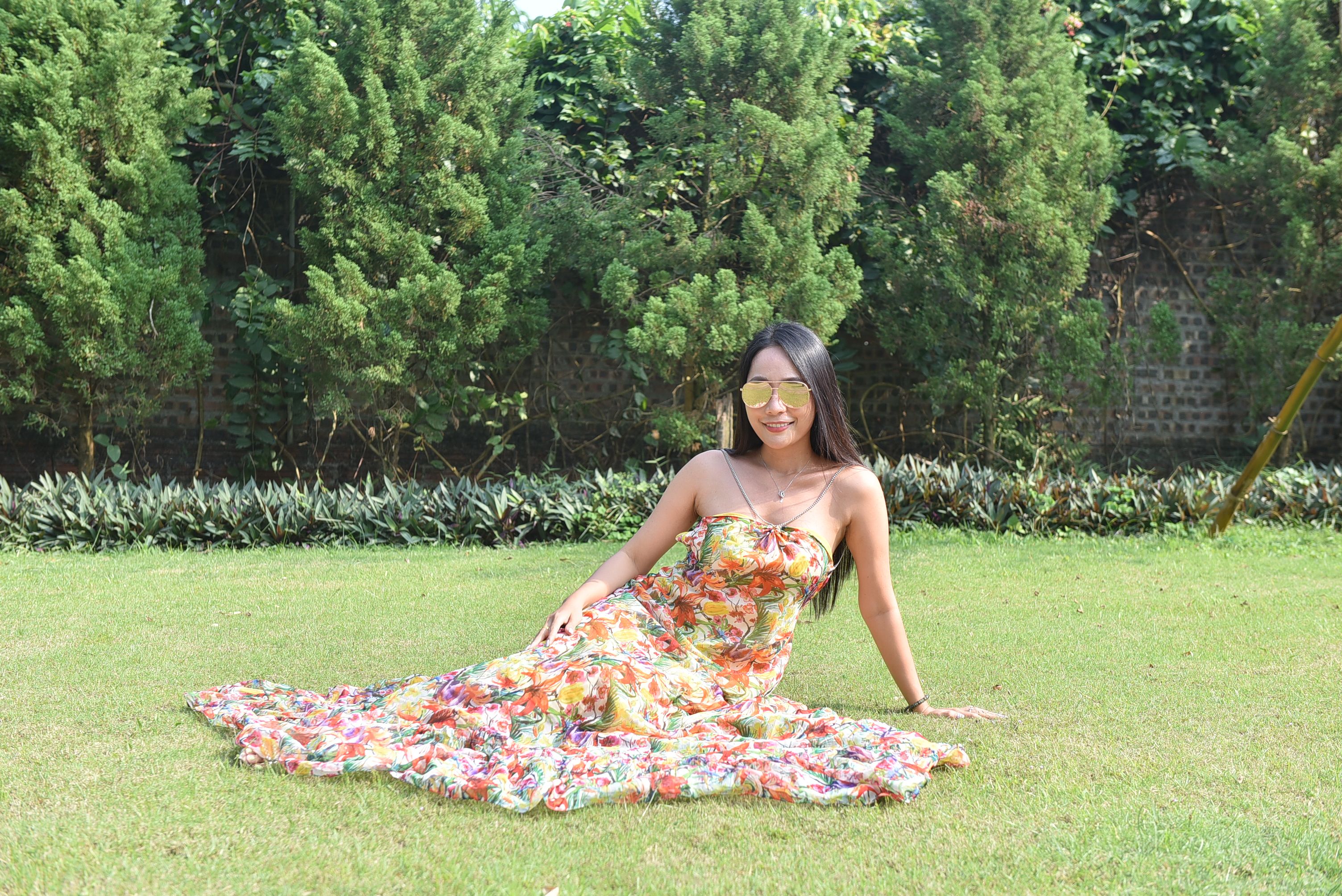 Woman in Floral Dress Relaxing in Sunny Garden · Free Stock Photo