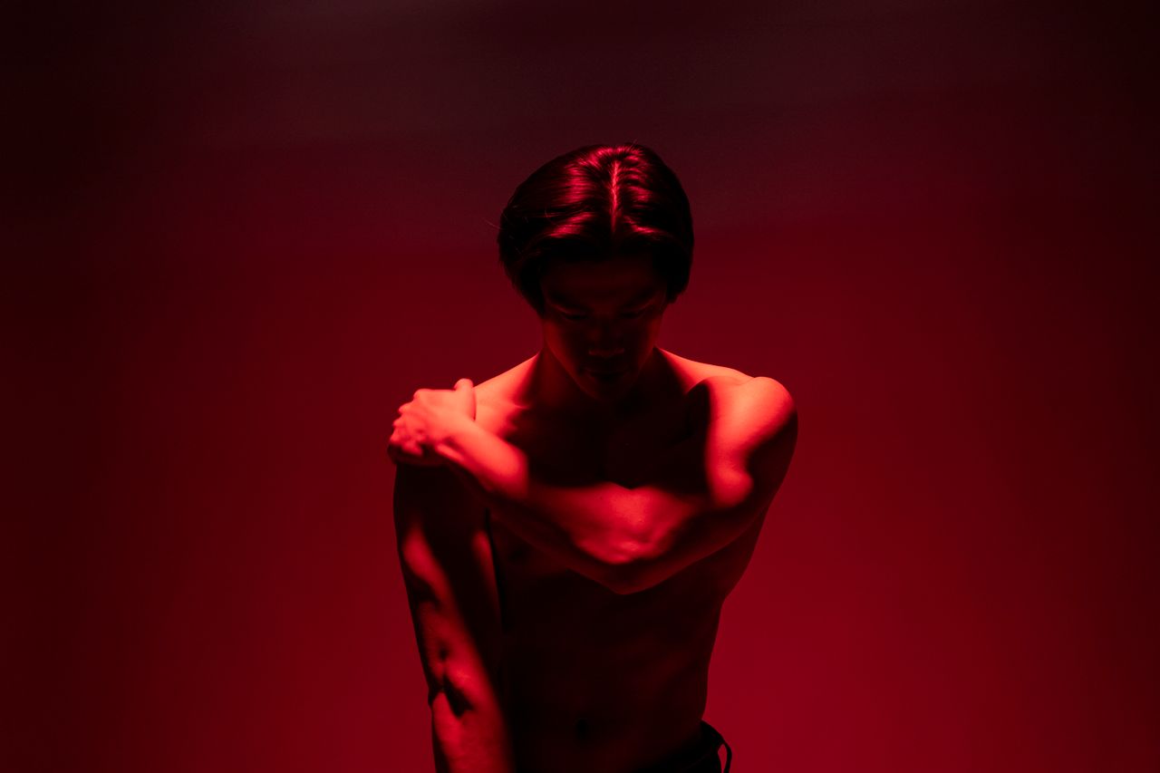 artistic portrait of a man with dramatic red lighting creating a moody