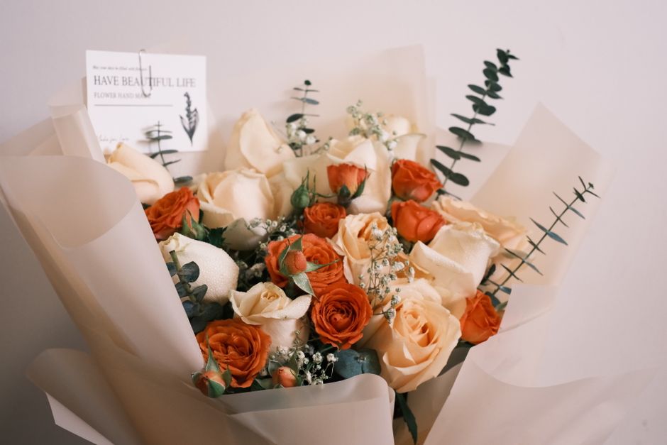 Beautiful bouquet of cream and orange roses with eucalyptus and baby's breath.