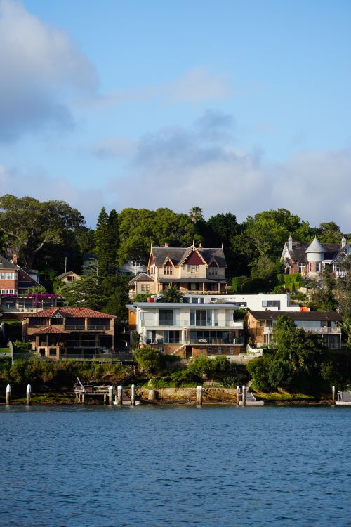 Free Scenic view of beautiful houses along a serene river, showcasing lush greenery. Stock Photo
