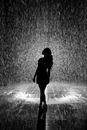 一个女人的艺术轮廓，在背光下戏剧性地享受着雨水