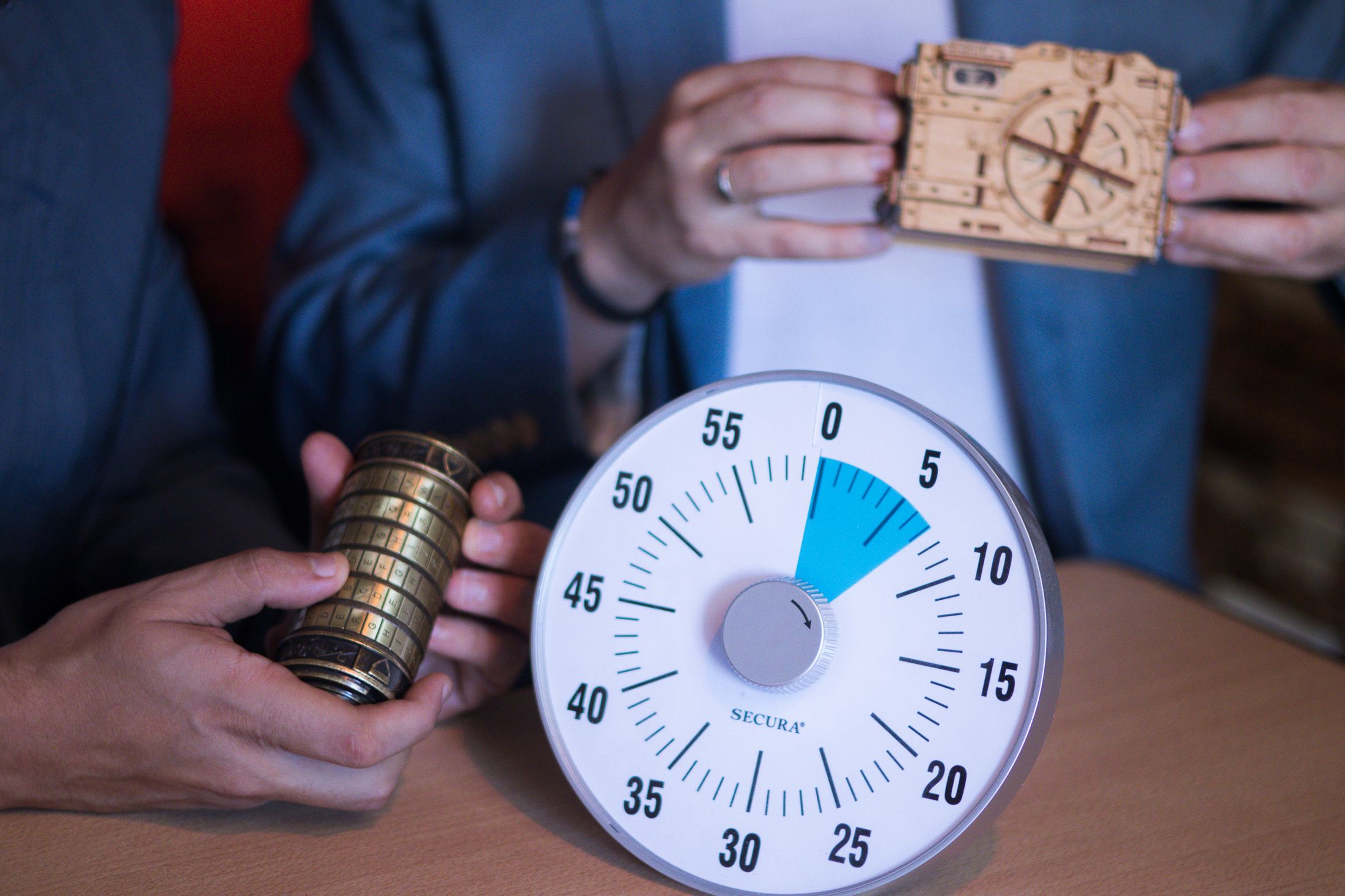 Joueur manipulant une énigme avec cadenas et chronomètre dans un escape game
