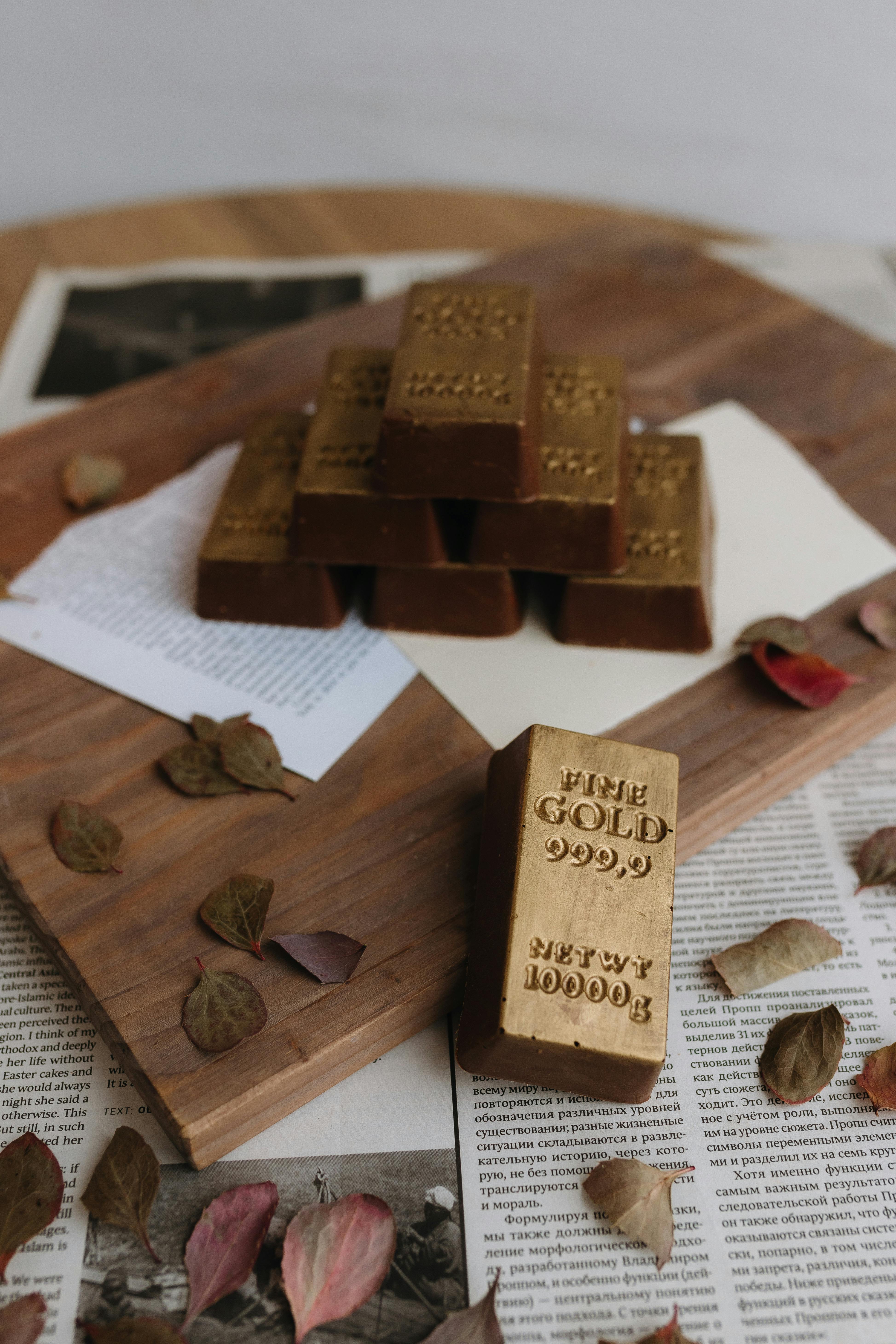 stack of gold bars on wooden surface