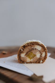 Close-up of a chocolate Swiss roll with cream filling and fruit center.