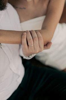 Intimate moment of a couple holding hands, showcasing wedding rings.