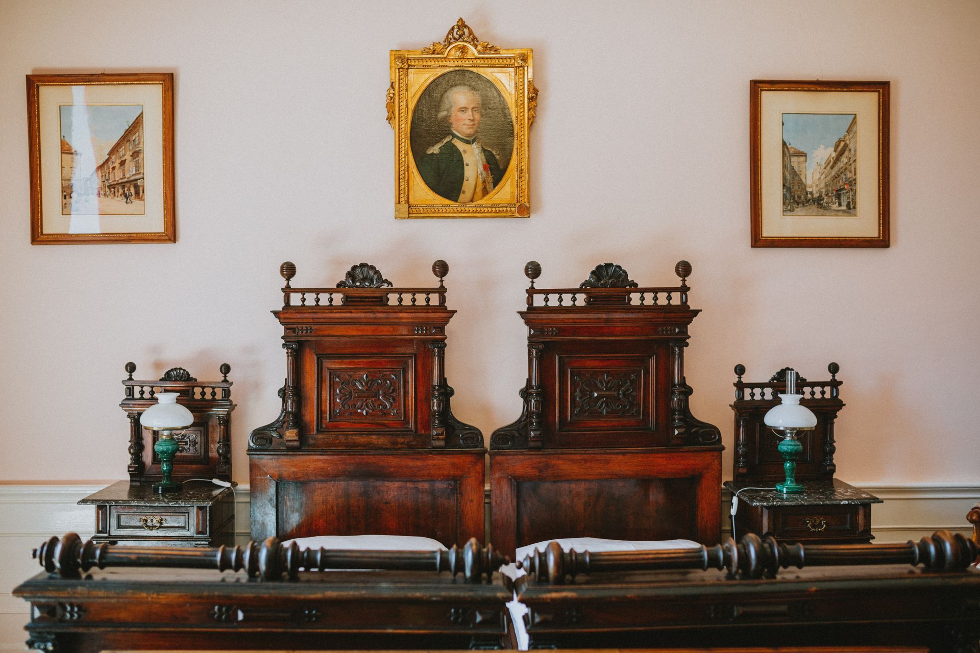 Vintage room with antique twin beds and wooden decor, highlighting 19th-century design.