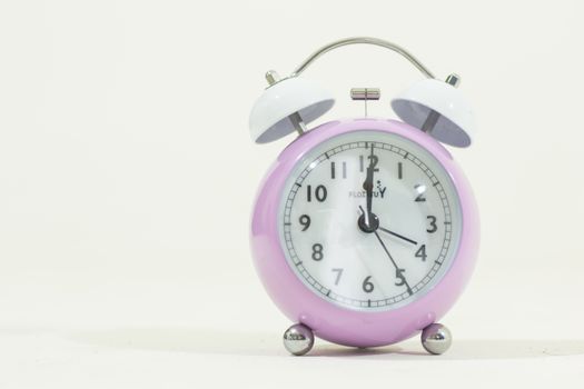 A lilac alarm clock with white bells, perfect for themes of time, punctuality, and minimalist design.