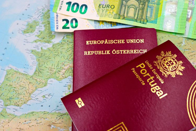 Pasaportes austriaco y portugués en un mapa europeo con billetes en euros.