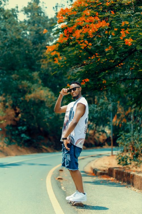 Free Young man skateboarding on a sunny day, nature background with vibrant flowers. Stock Photo