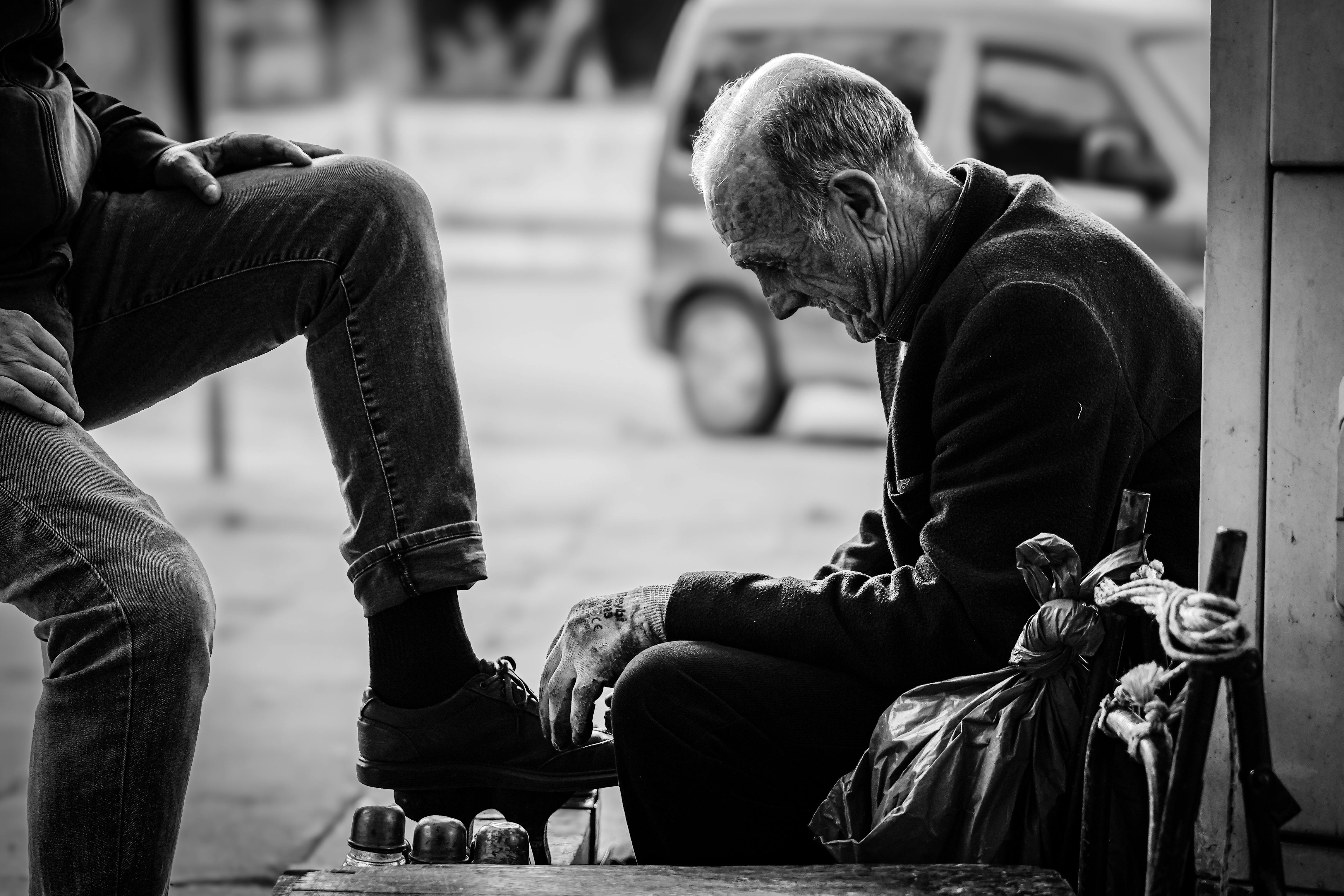 black and white street photo of a shoe shiner in istanbul