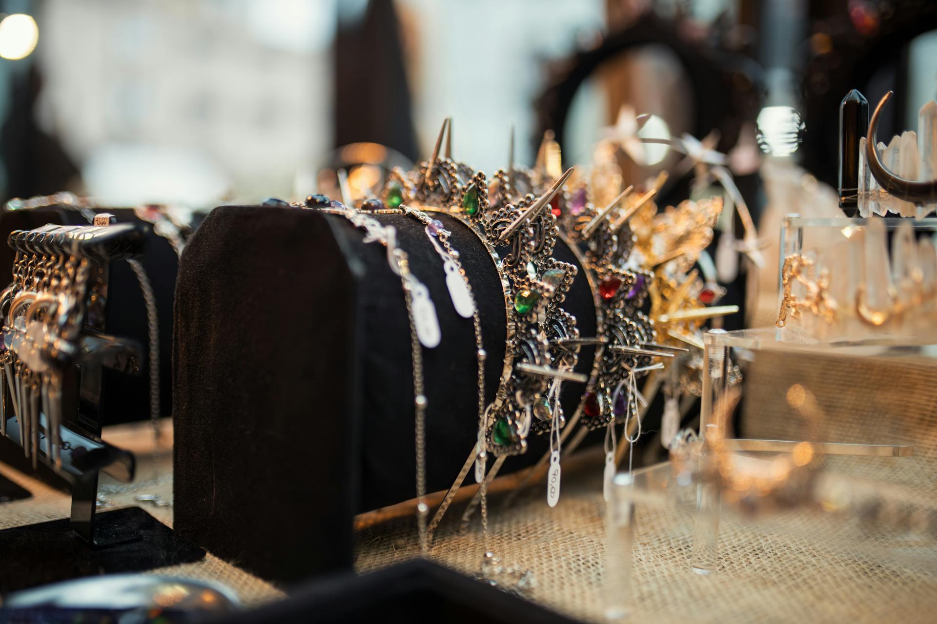 Crown and jewelry display showcasing elegant gemstones and intricate designs on a velvet stand.