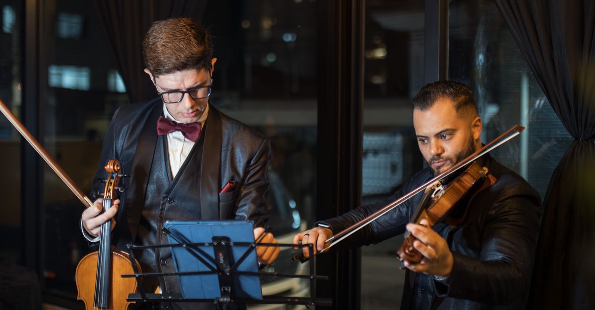 Two Musicians Performing Violin Duet Indoors · Free Stock Photo