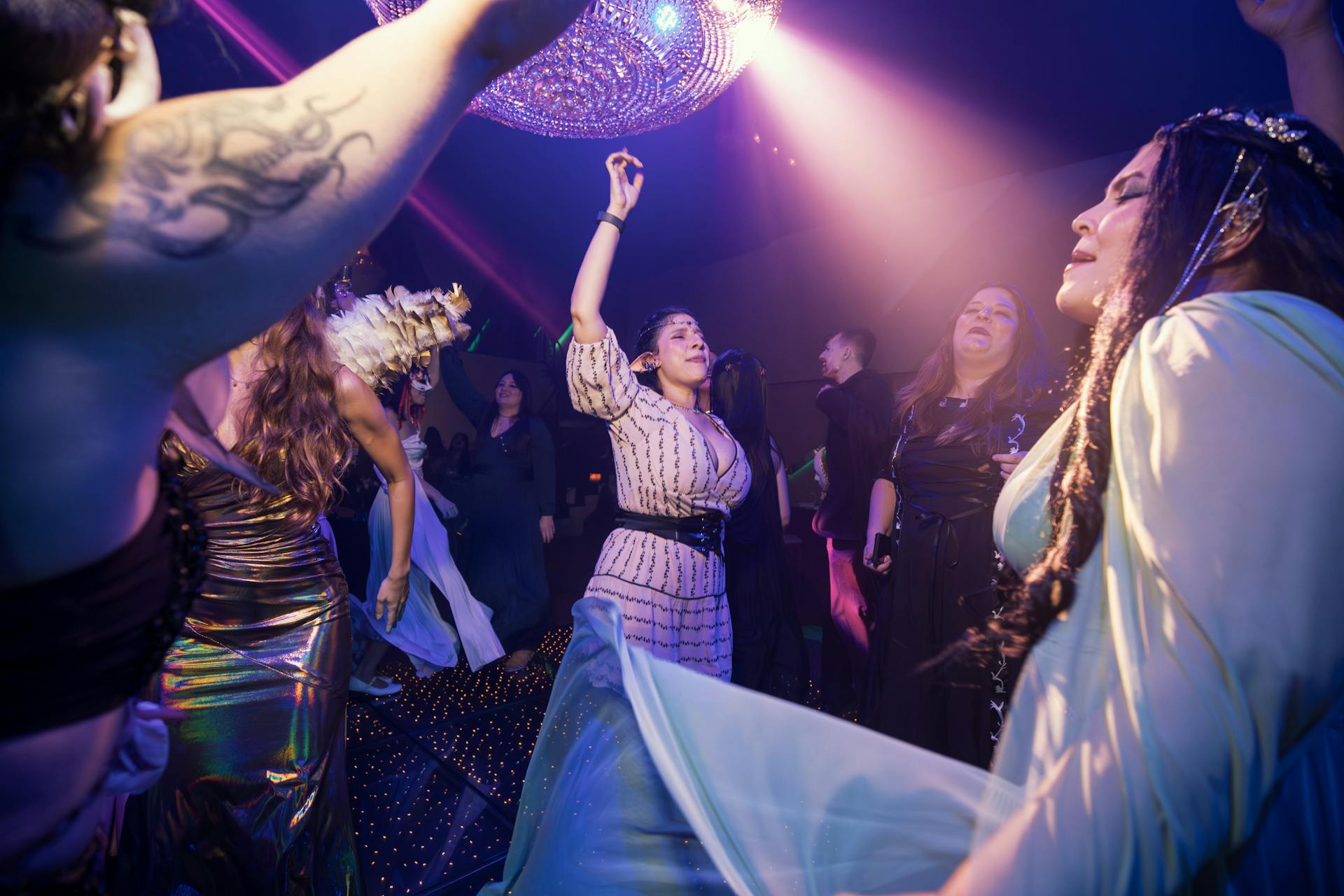 Energetic dance scene at a vibrant indoor party with joyful people under colorful lights.