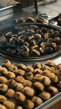Close-up of freshly roasted chestnuts on a street vendor's stove, creating a delightful aroma.