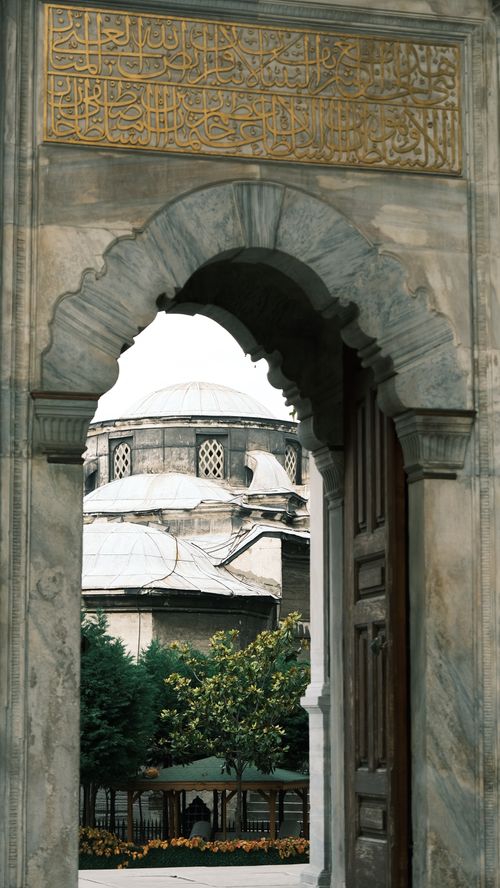Free View of Ottoman dome and garden through a traditional stone archway. Stock Photo