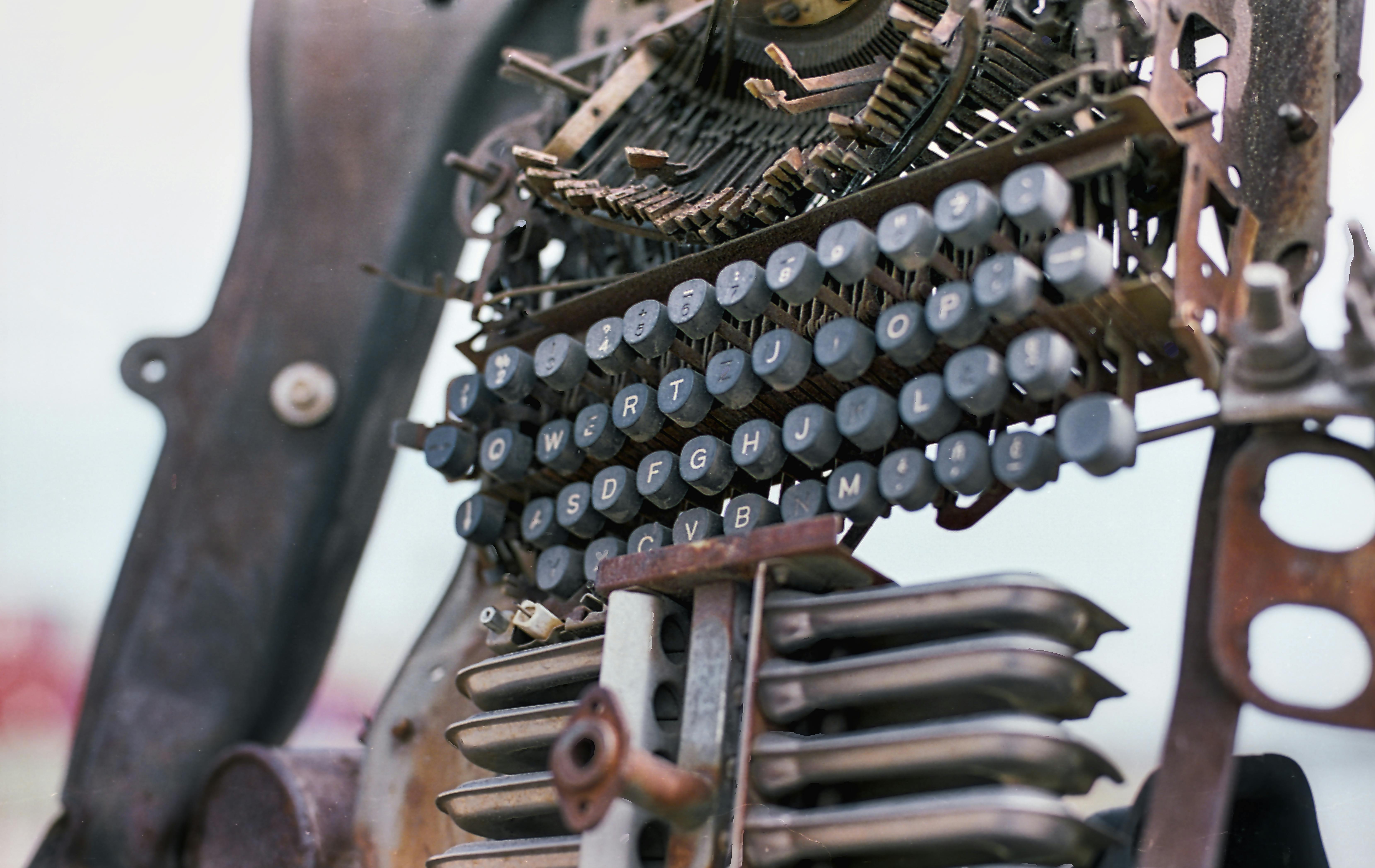 Close-up of an old typewriter with visible mechanics, showcasing rustic beauty.