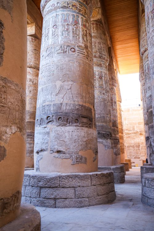 Free Intricately carved columns with hieroglyphs in an ancient Egyptian temple, showcasing historical art. Stock Photo