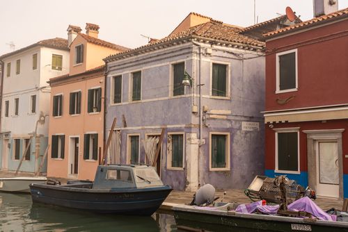 Free Colorful canal houses in Burano, Venice, with boats reflecting Venetian charm. Stock Photo