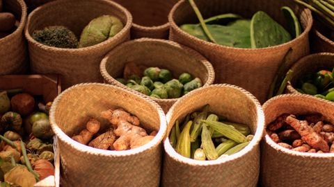 Colorful baskets of fresh vegetables at a Mexican market showcasing a variety of produce.
