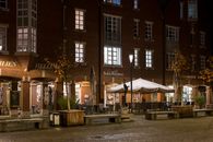 Captivating night view of a cozy European cafe with warm lighting and autumn ambiance.