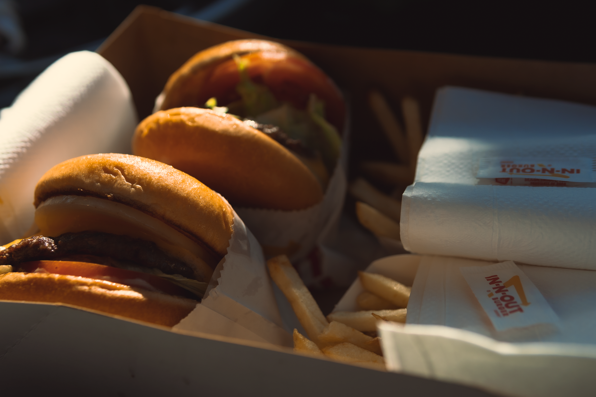 Close-up of In-N-Out burgers and fries in a takeout box, showcasing fast food delight.
