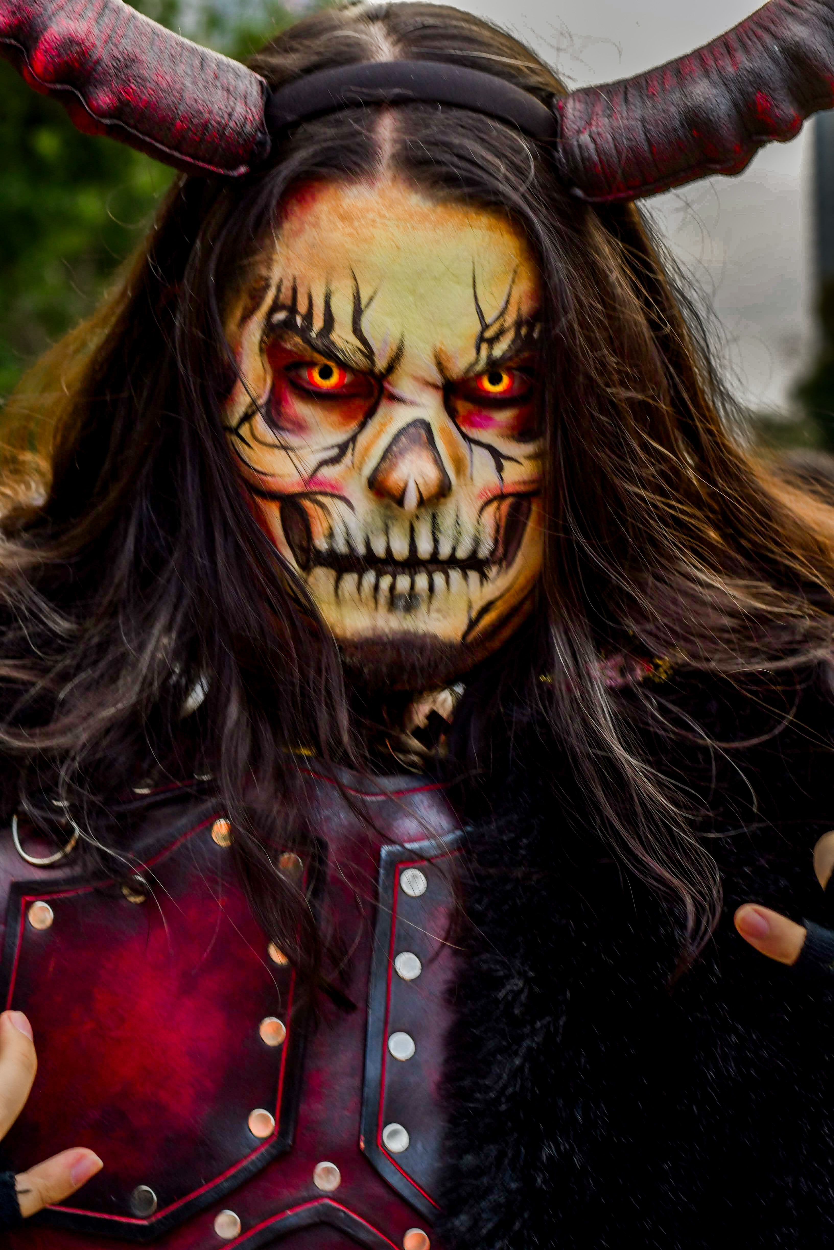 A thrilling close-up of a person in demon costume with detailed makeup and horns.