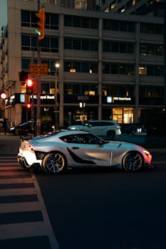 A sleek Toyota Supra parked at an intersection in Toronto during nighttime.
