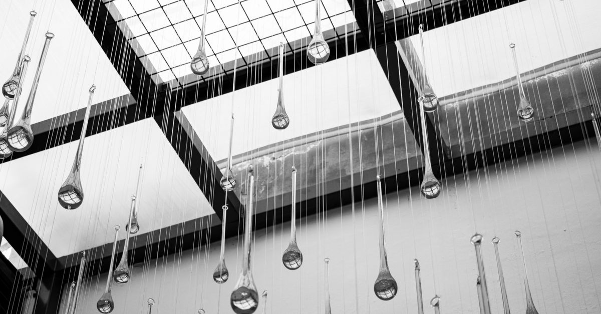 Abstract black and white photo of hanging glass sculptures in a modern atrium ceiling.